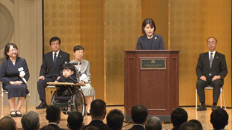 両陛下の前で体験を語る樋口てるみさん（右）と長男・健太郎さん（左）