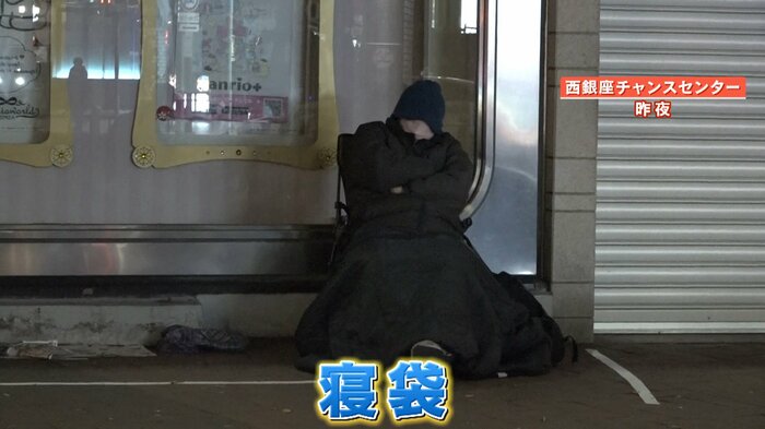 寝袋で暖をとる西田さん
