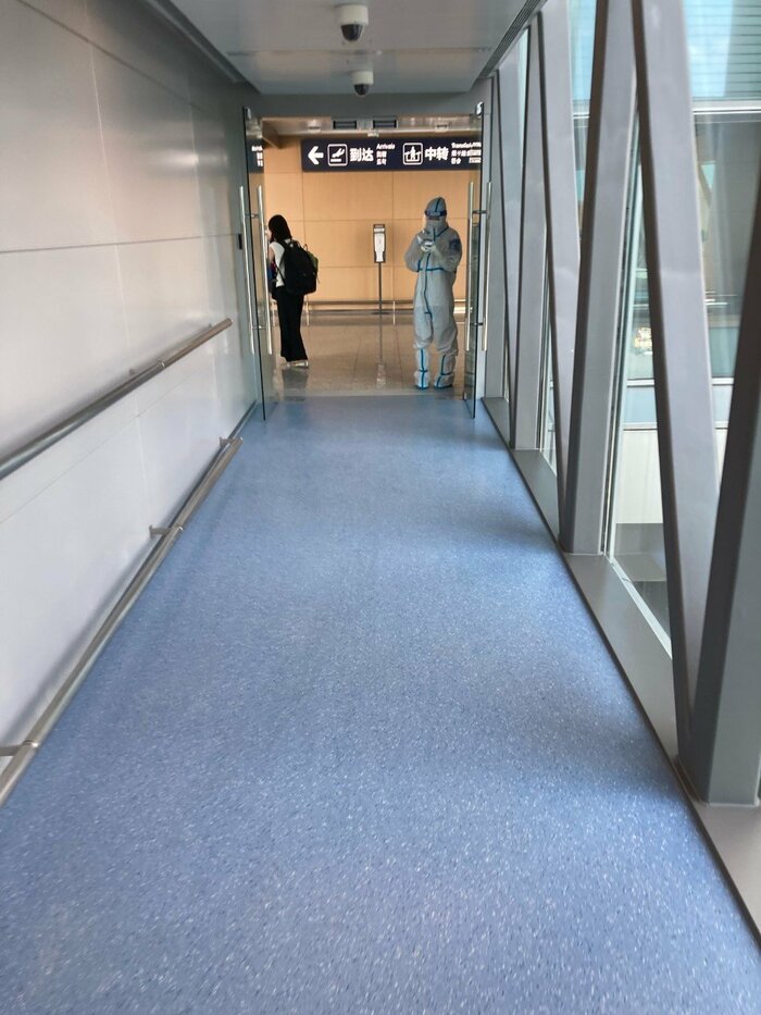 飛行機を降りると防護服をまとったスタッフの姿が