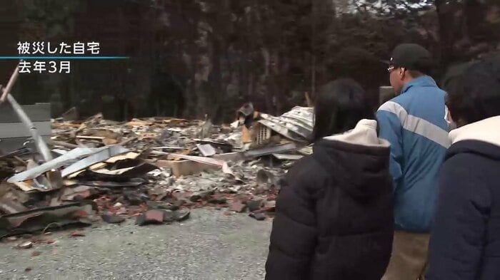 跡形もなく焼け落ちた自宅を見つめる泉さん家族