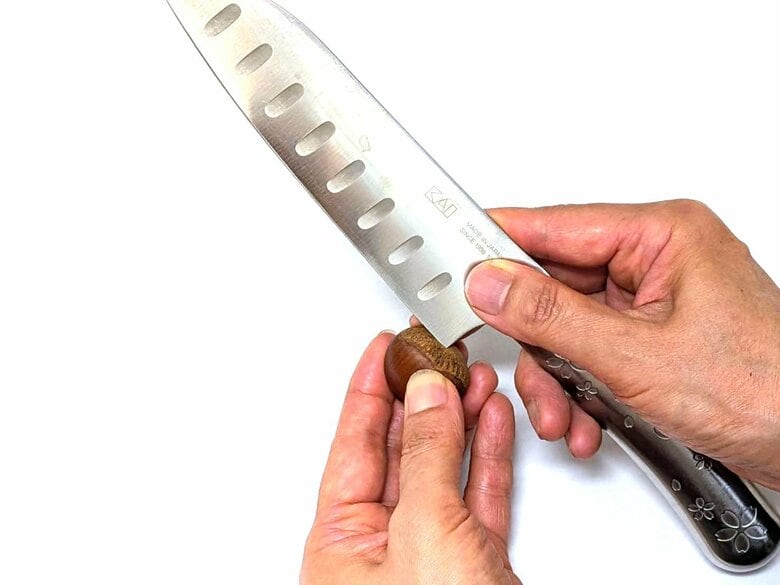 栗の座に包丁の刃の手前の角で傷をつけ、そこから鬼皮をむきます
