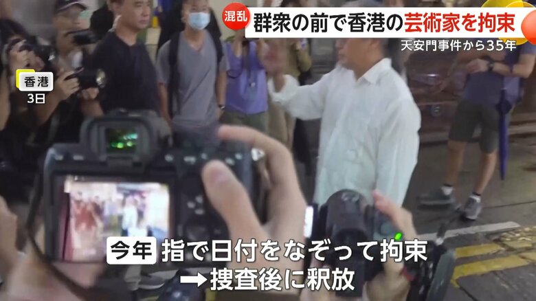 手で空を切るように、漢数字の六と四と書いた芸術家の男性