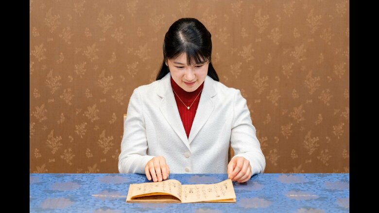 室町時代に書き写された「百人一首」の写本をそっとめくり、清少納言などの和歌に目を通される愛子さま（宮内庁提供）