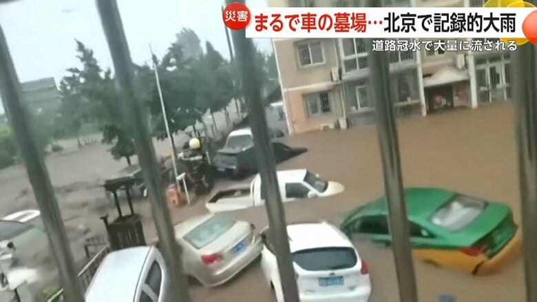 記録的大雨の影響で大量の土砂とともに流されている車