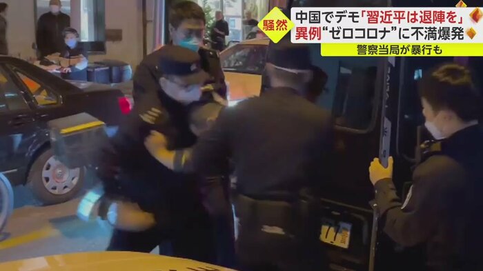 デモ参加者の腹を、拳で殴る警察官