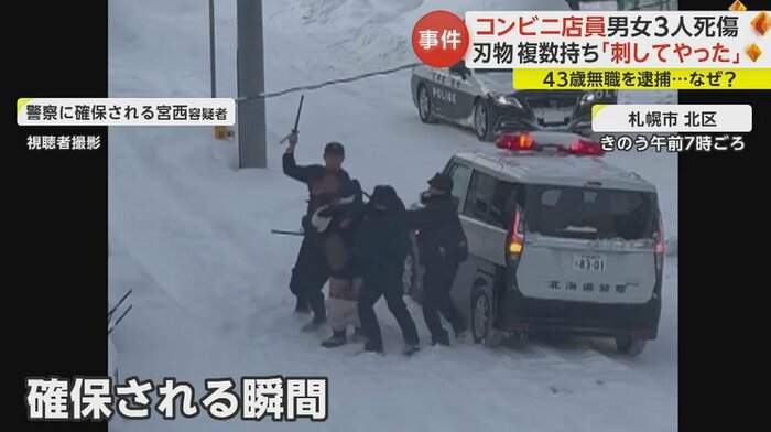 激しく抵抗する容疑者を警察官3人が取り押さえている