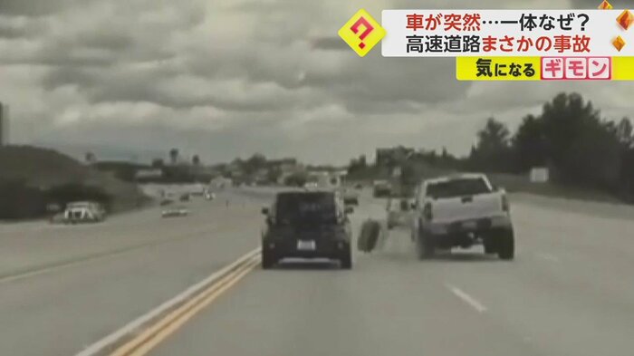 外れたタイヤは黒い車の前に…