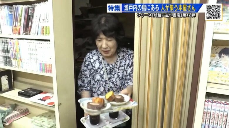 本棚の間からコーヒーとおやつを手に現れる店主