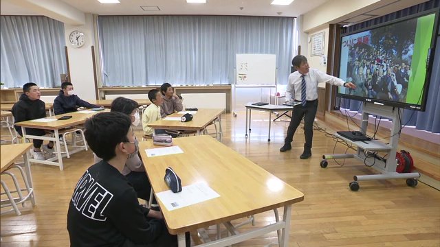校長が児童たちにスライドを使って説明