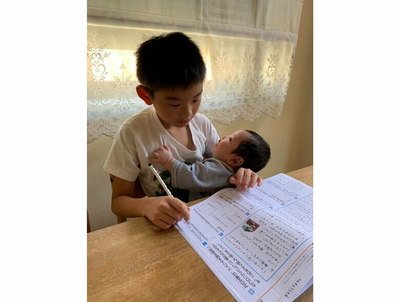 生後2カ月のぴーぴーくんを抱きながら勉強するにゃんぽんくん（提供：ゆめの｜男の子3人の母｜楽しむ子育てさん）