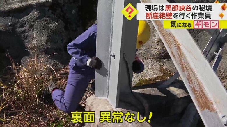 山の尾根にそびえる鉄塔を点検する関西電力送配電の社員