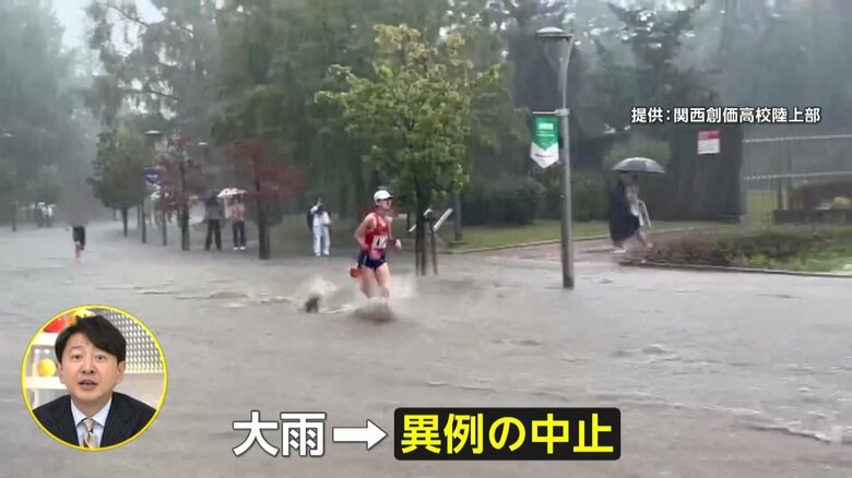 大雨の中を水しぶきを上げて走る選手