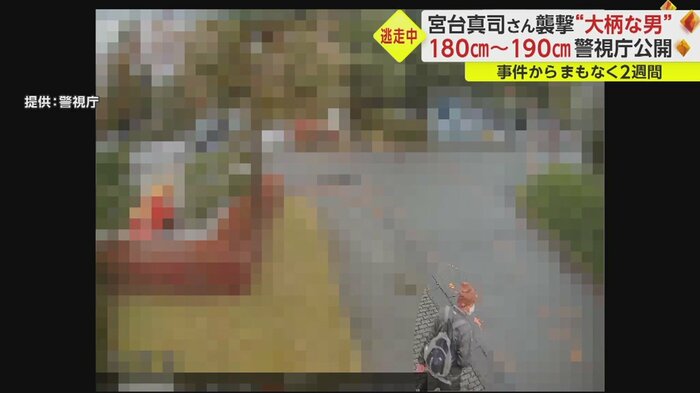 一瞬振り返るニット帽の男