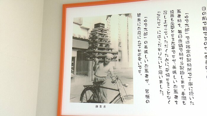 店内に掲げられた古い写真 男性の肩には8段ものそばが