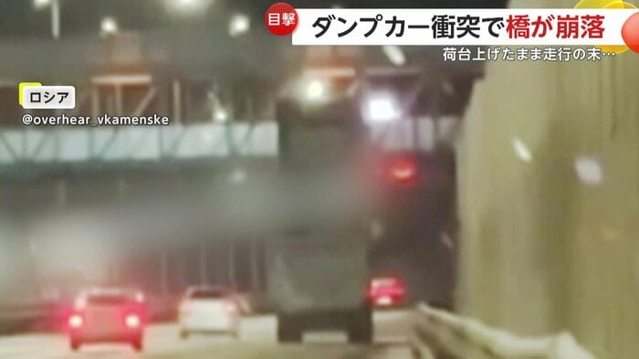 荷台を上げたまま橋に近づくダンプカー