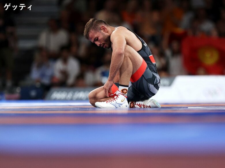 靴に手をかけるイランのモフセンネジャド選手