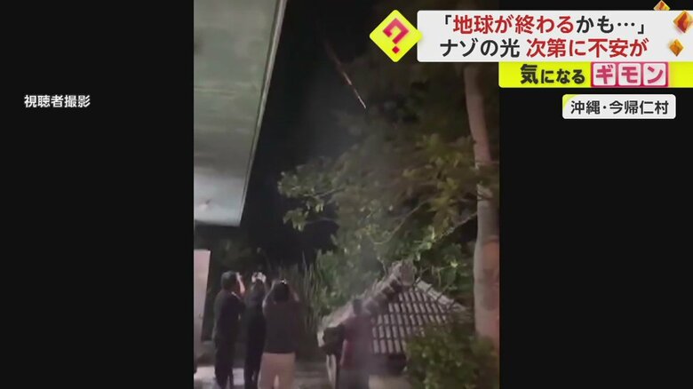 空に現れた白い光に驚きカメラを向ける人々