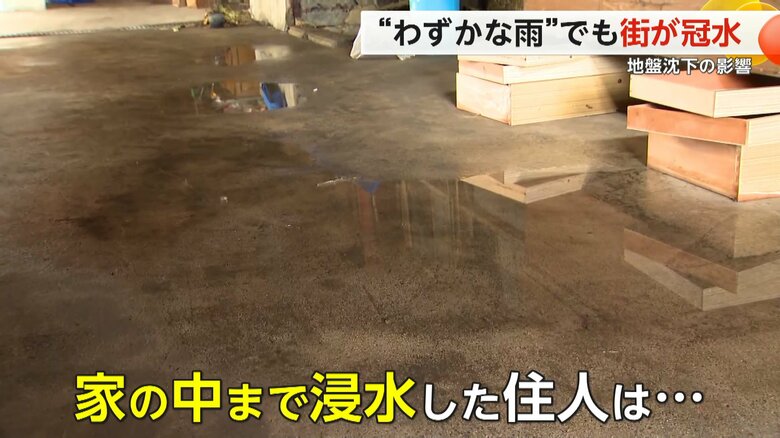 地盤沈下の影響で冠水し、水で濡れた道路
