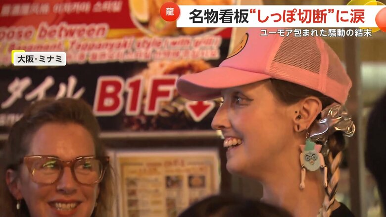 しっぽ切断を見守る外国人観光客