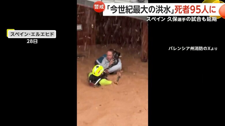 下半身が水に浸かった状態で犬を抱き抱える人が犬と共に吊り上げられ救助される一部始終①