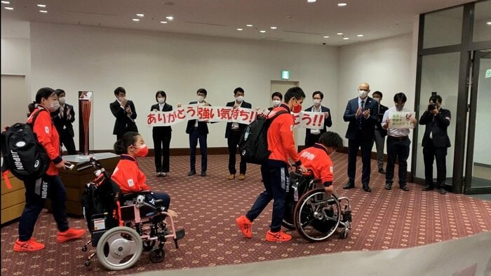 木村選手、鈴木選手らをお見送りをする職員らと室伏長官