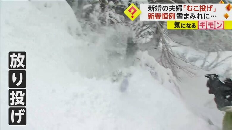 雪の斜面に放り投げられるむこ