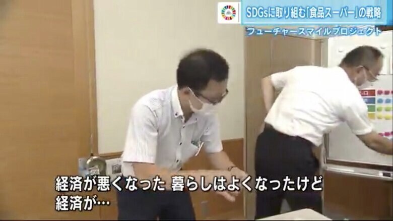 ホワイトボードの「地域の状況メーター」を管理するスタッフ