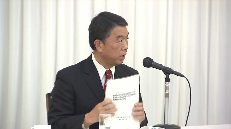 仙台市がまとめた4病院再編に関する資料を手に語気を強める村井知事