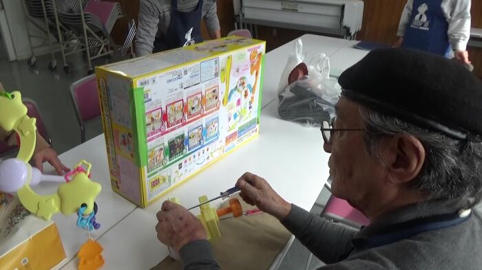 持ち込まれたおもちゃを診察する高橋さん
