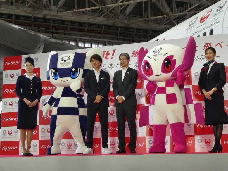 JAL赤坂社長と嵐・櫻井さん。右は現行の制服、左は1964年東京五輪当時の制服
