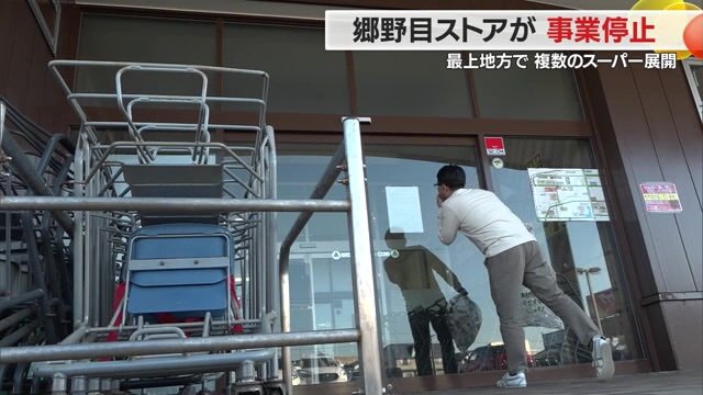 入り口に貼られた「告示書」を見る客