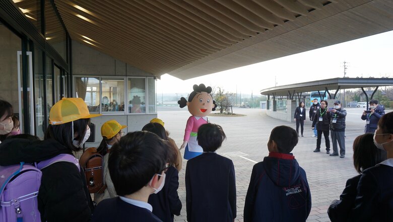 ハイタッチ後も、サザエさんに興味津々の小学生（志賀小学校）