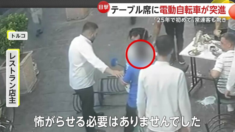 少年に声をかける店主（IHA）