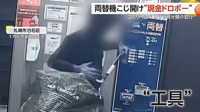 バッグからバールのような工具を取り出す人物（防犯カメラの映像）