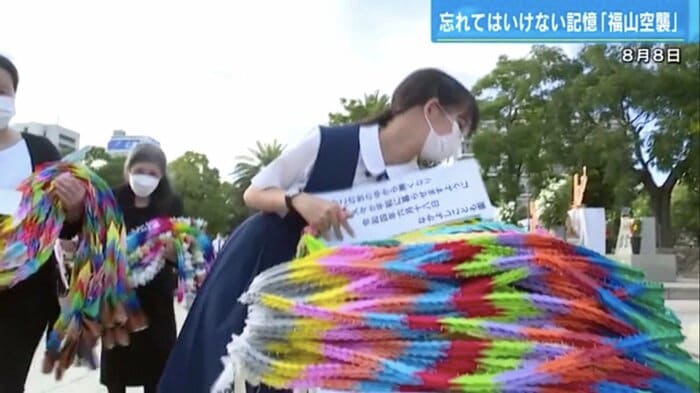 慰霊碑前に折り鶴をささげる参列者
