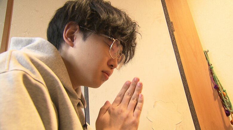 曾祖父の仏前に手を合わせる原田晋之介さん