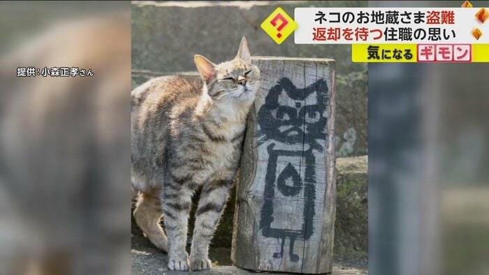 木で作られたネコのお地蔵さまに身を寄せるネコ