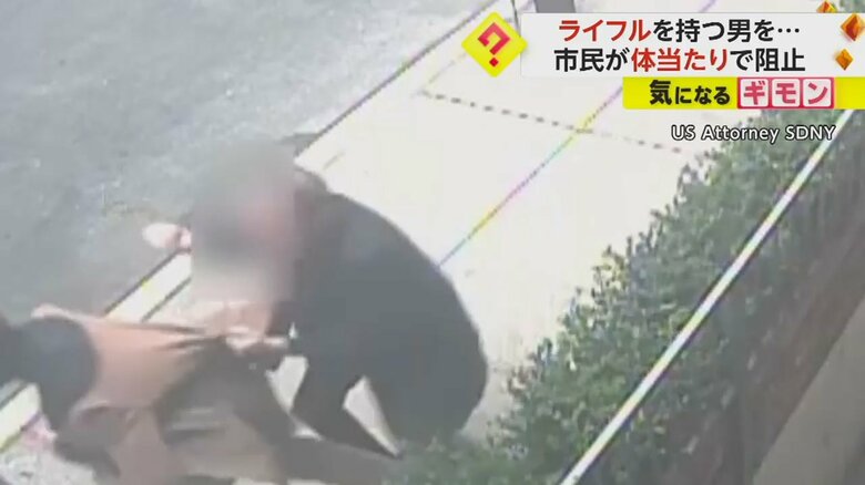 銃を持った男を取り押さえる男性