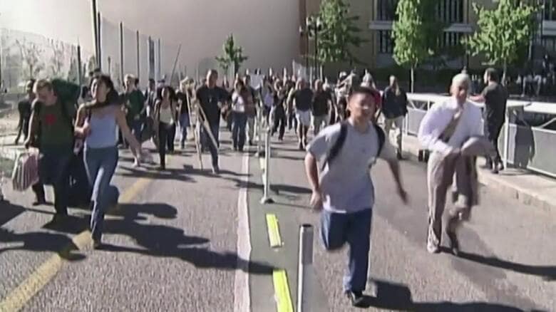 2001年9月11日。川沿いの道を走る若者たち。煙が迫り来ている