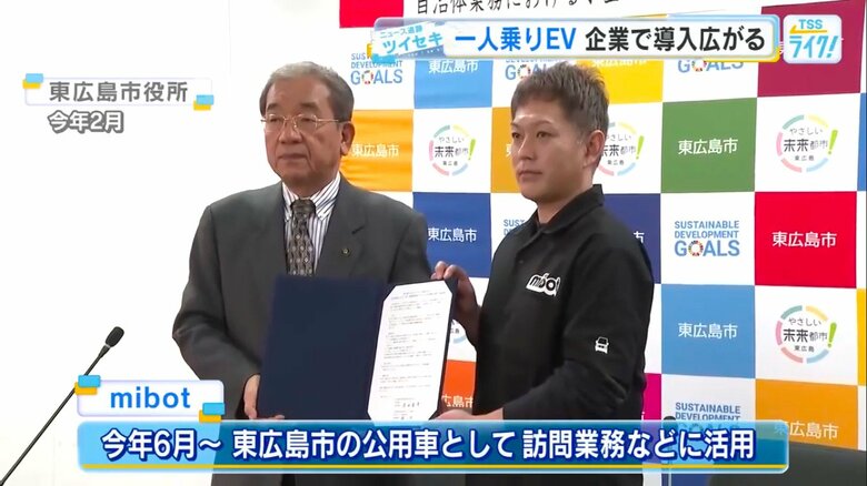 東広島市役所で会見するKGモーターズの楠一成CEO（右）