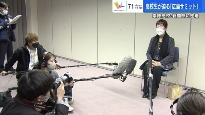 被爆者の田中稔子さんを囲む報道陣と新聞部