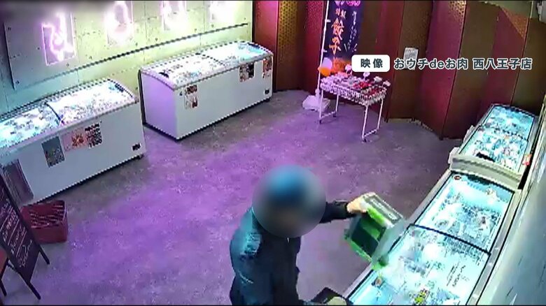 売り上げが入った料金箱を手に取る男