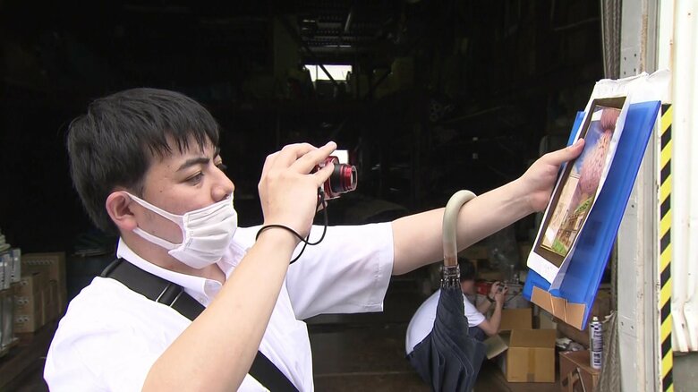 絵と同じ構図をカメラに収める小松さん