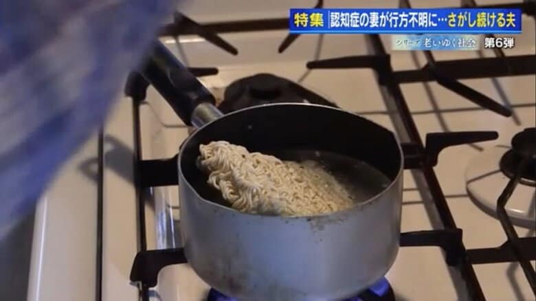 自宅の台所でインスタントラーメンを作る夫