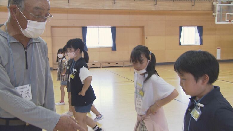 子どもたちに神楽の舞を指導する　高山一男さん