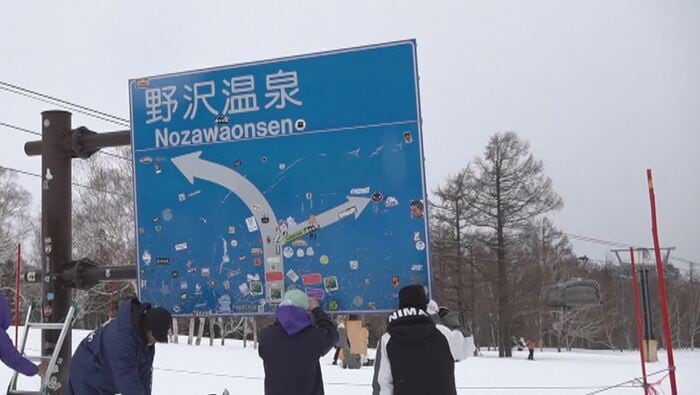 ステッカーをはがす職員ら