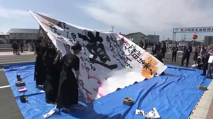 開通式典で披露された地元の学生による書道パフォーマンス
