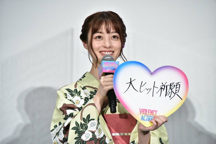 「大ヒット祈願」の色紙を持ち、笑顔の橋本環奈さん (C)浅井蓮次・沢田 新・小学館/『バイオレンスアクション』製作委員会