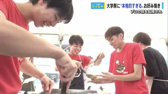 目のまわるような忙しさでお好み焼きを焼く学生たち