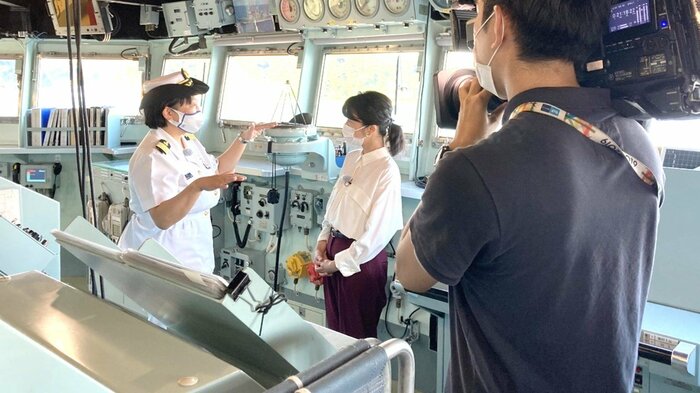 護衛艦「てるづき」の艦橋を案内する小野小百合1佐(左)